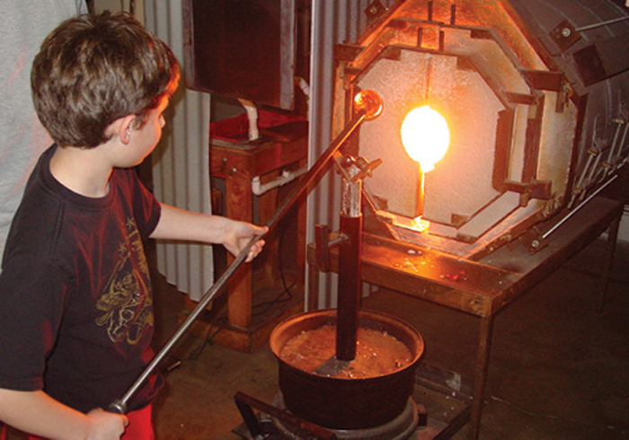 Boy Blowing glass to make his own ornament